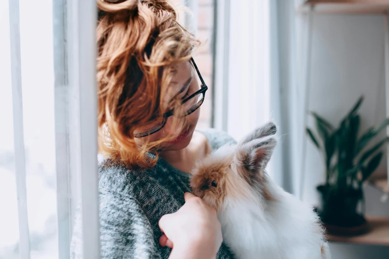 a woman holding a cat in her arms, pexels contest winner, anthropomorphic rabbit, avatar image, girl with messy bun hairstyle, half - length photo