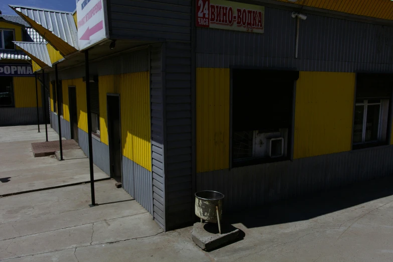 a yellow and gray building sitting on the side of a road, by Attila Meszlenyi, convenience store, 000 — википедия, photography alexey gurylev, game environment