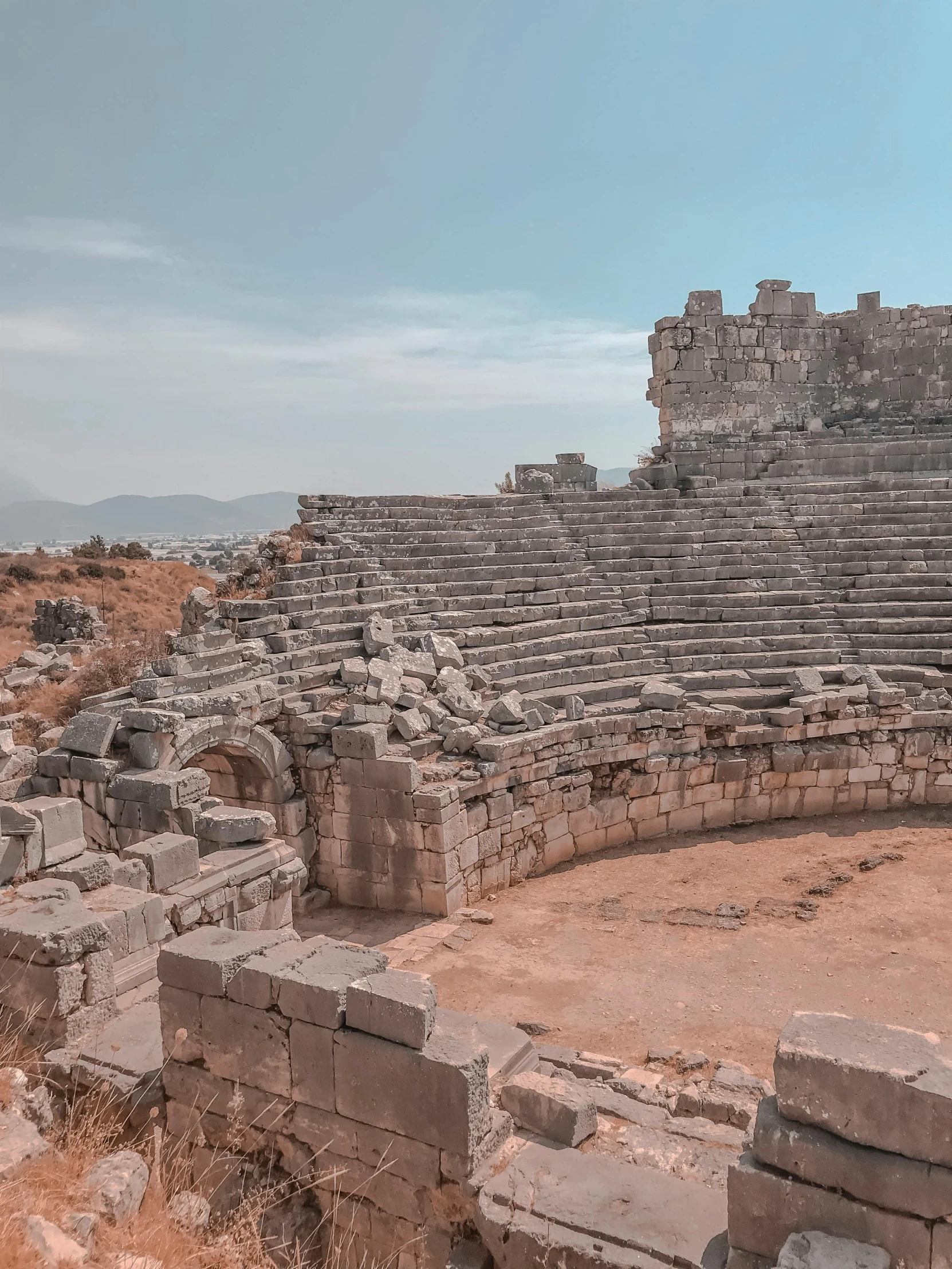 a large stone structure sitting on top of a dirt field, a colorized photo, pexels contest winner, ancient mediterranean city, mini amphitheatre, staggered terraces, wide high angle view