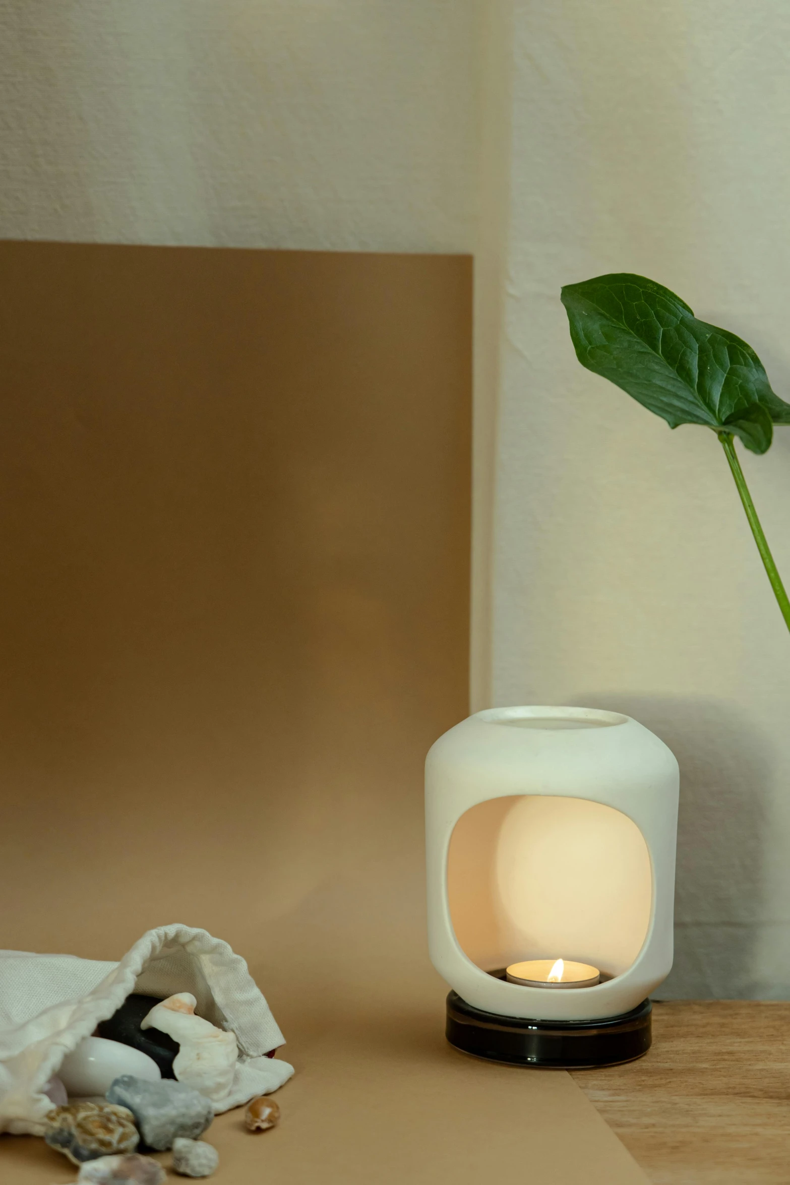 a white vase sitting on top of a wooden table, holding a candle holder, brightly lit room, healing pods, softlight