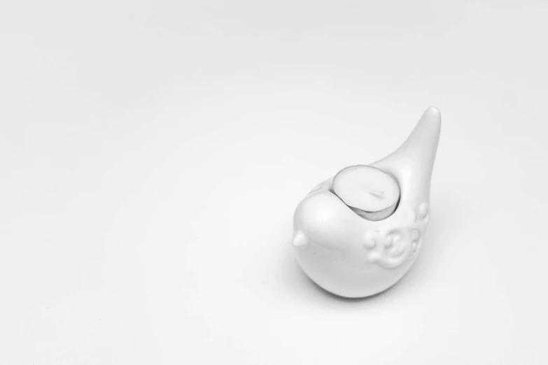 a white bird figurine sitting on top of a table, an ambient occlusion render, by Jan Kupecký, snail shell, candle, product introduction photo, commercial product photography