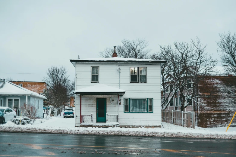 a white house sitting on the side of a road, by Andrew Stevovich, pexels contest winner, greg rutkowski winter, old apartment, in a suburb, cinestill 800t eastmancolor