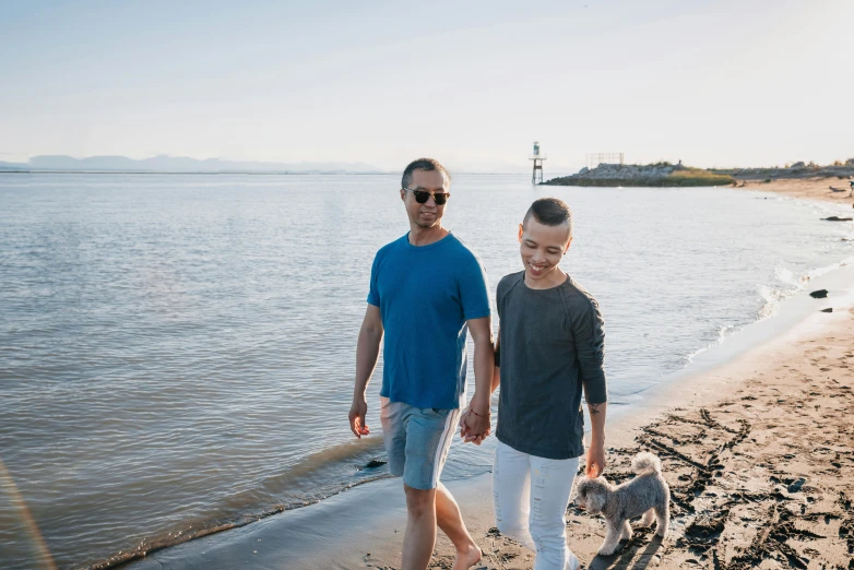 a man and a woman walking a dog on a beach, pexels contest winner, happening, brunette boy and redhead boy, father figure image, non-binary, seattle