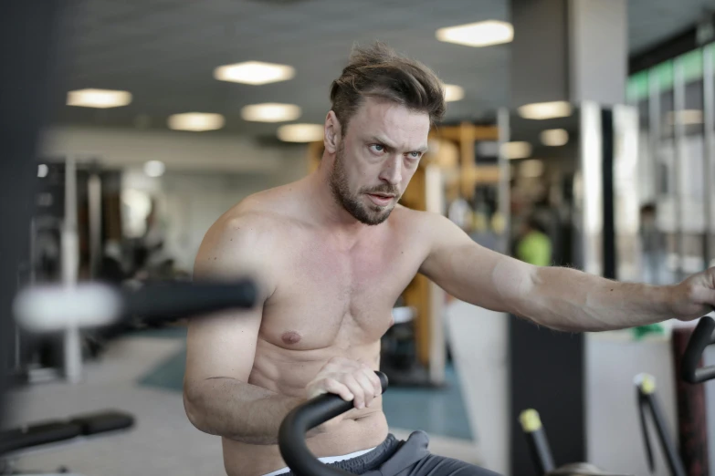 a shirtless man working out on a stationary bike, by Julian Allen, pexels contest winner, happening, avatar image, manly face, marton csokas, swanland