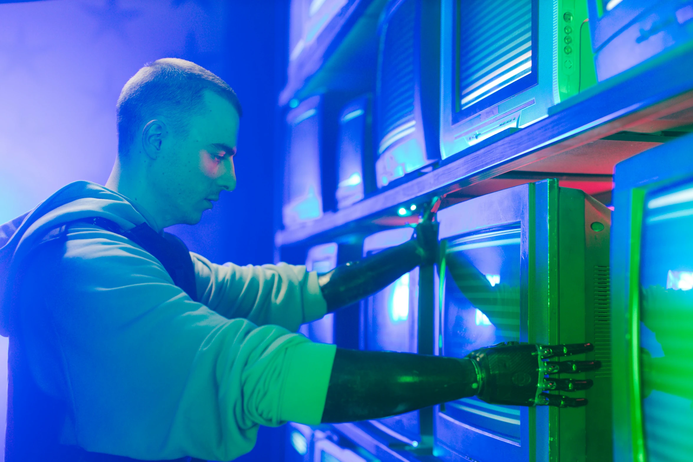 a man that is standing in front of a rack, by Dan Luvisi, unsplash, holography, brightly lit blue room, pacing in server room, production still, opening scene