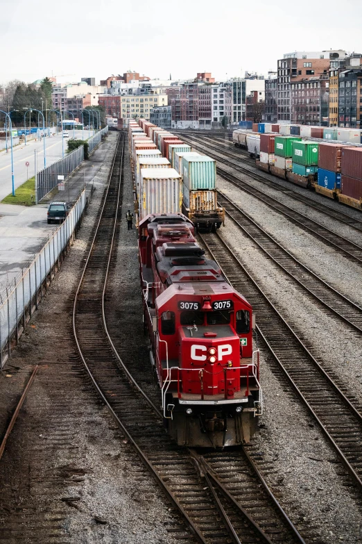 a train traveling down train tracks next to a city, shipping docks, toronto, high quality picture, cp2077