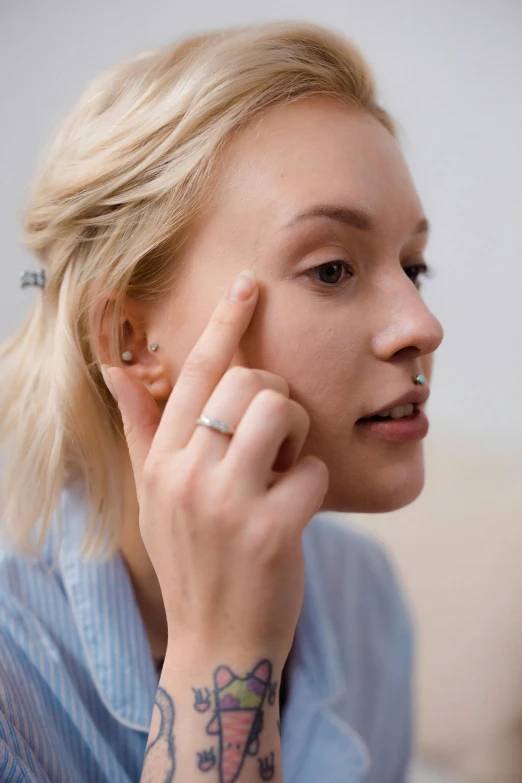 a woman sitting on a couch talking on a cell phone, a digital rendering, trending on pexels, renaissance, eyebrow scar, square facial structure, close up of a blonde woman, pimples