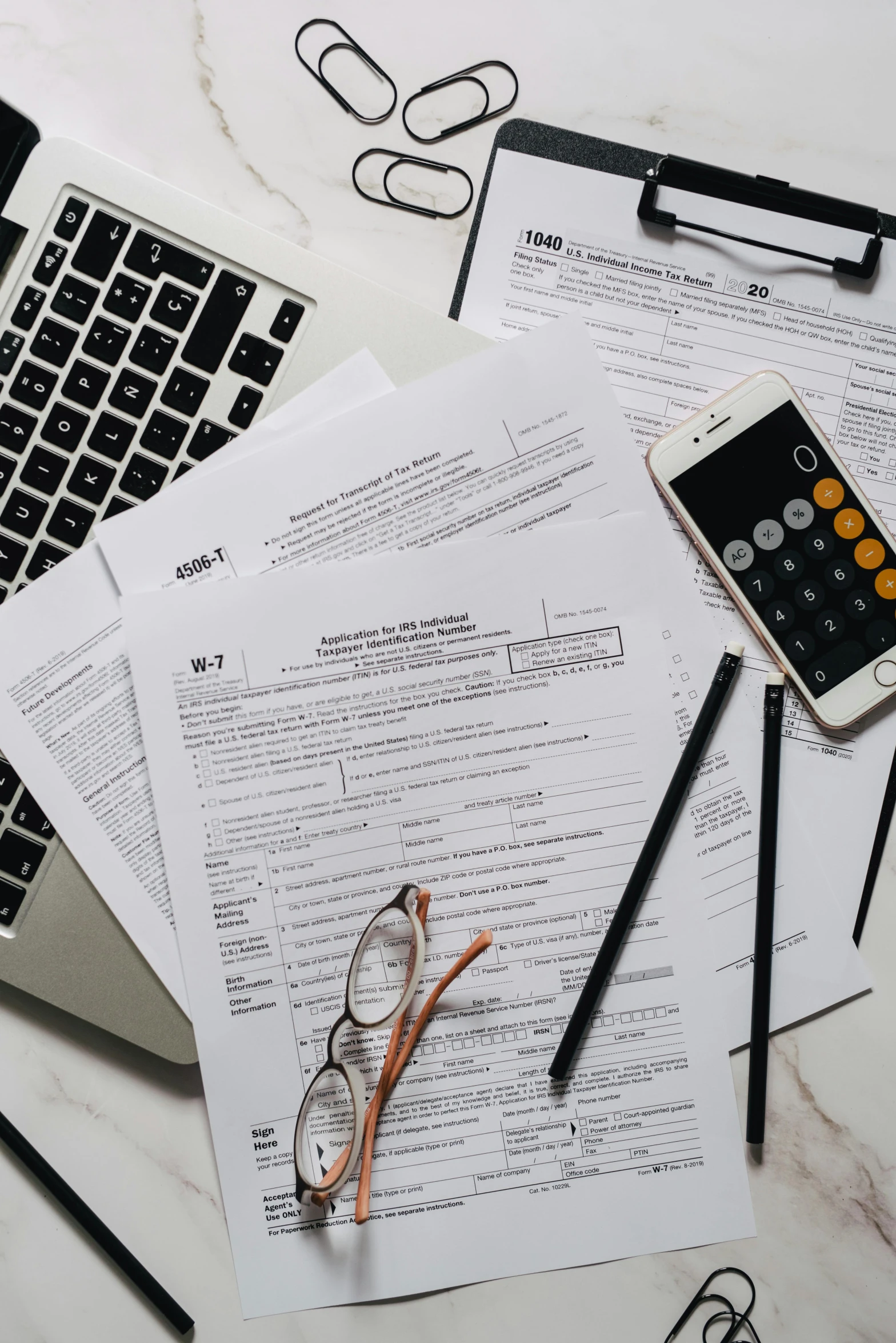 a laptop computer sitting on top of a pile of papers, by Carey Morris, trending on pexels, currency symbols printed, thumbnail, dnd), low quality photo