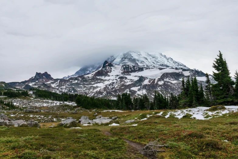 a mountain covered in snow on a cloudy day, inspired by Thomas Struth, unsplash contest winner, mountain behind meadow, seattle, panoramic shot, hiking in rocky mountain