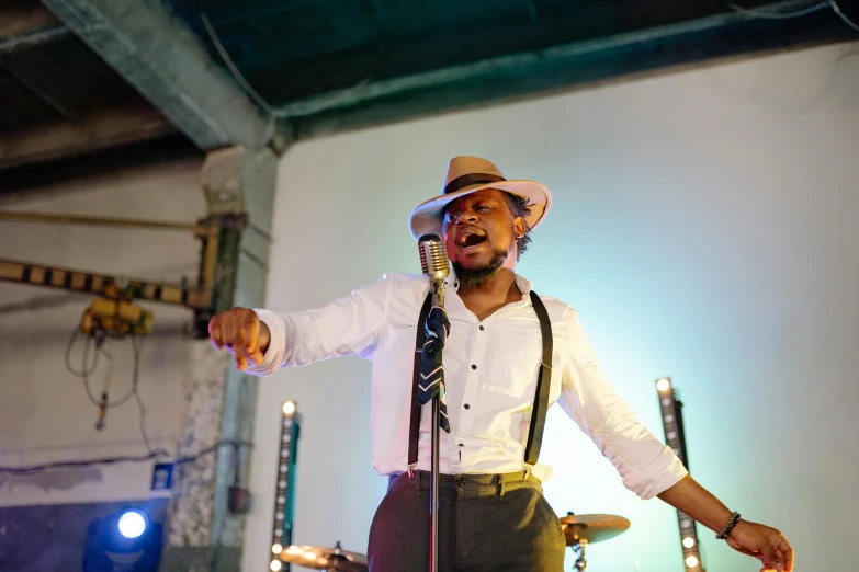 a man in a hat singing into a microphone, pexels, happening, wedding, square, emmanuel shiru, confident pose