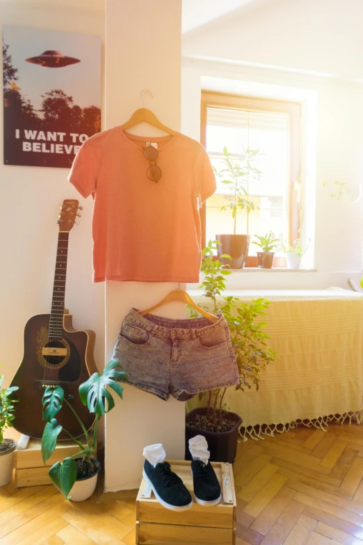 a bed room with a bed and a guitar, a picture, inspired by Elsa Bleda, pexels contest winner, croptop and shorts, toned orange and pastel pink, cropped red yoga short, jeans and t shirt