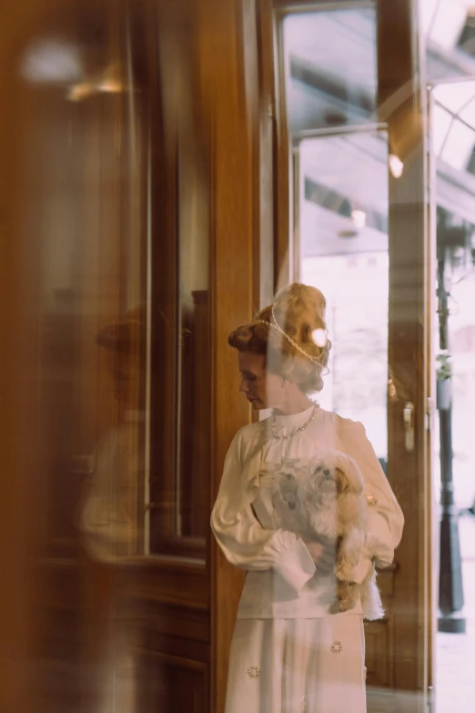 a statue of a woman standing in front of a door, inspired by Paul Cornoyer, unsplash, medium format. soft light, shopwindows, vintage footage, victorian clothing