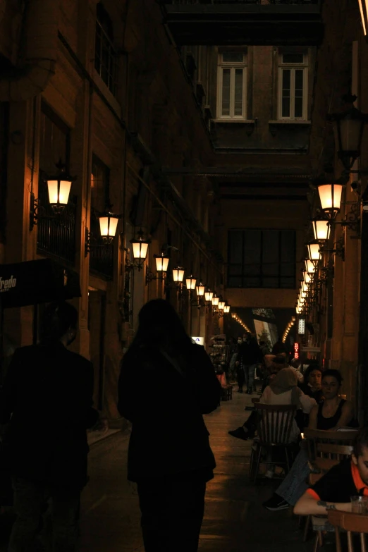 a group of people walking down a street at night, by Hirosada II, cafe lighting, agrigento, hallways, completely empty