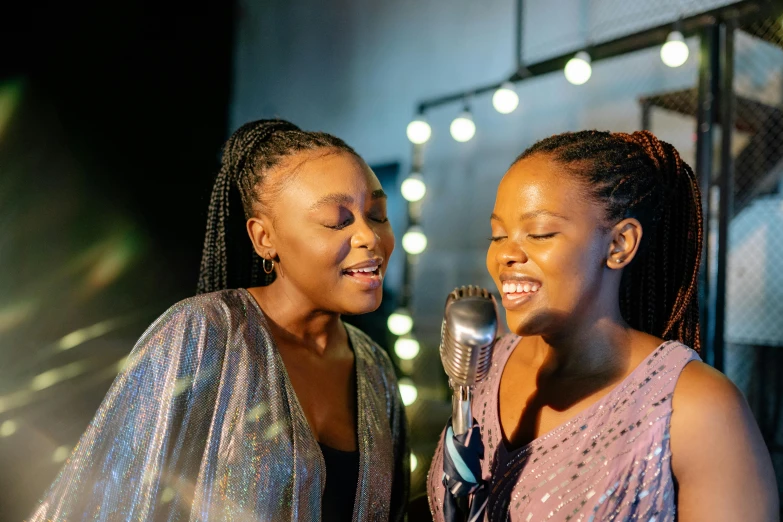 a couple of women standing next to each other, an album cover, by Ella Guru, trending on pexels, happening, singing into microphone, african sybil, sparkling light, 15081959 21121991 01012000 4k