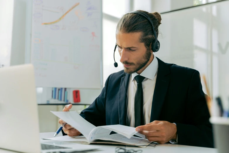 a man sitting at a desk in front of a laptop wearing a headset, pexels contest winner, hurufiyya, reading engineering book, royal commission, business attire, youtube thumbnail