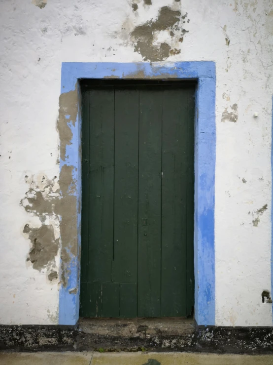 a blue and white building with a green door, dirty olive skin, azores, square, low quality photo