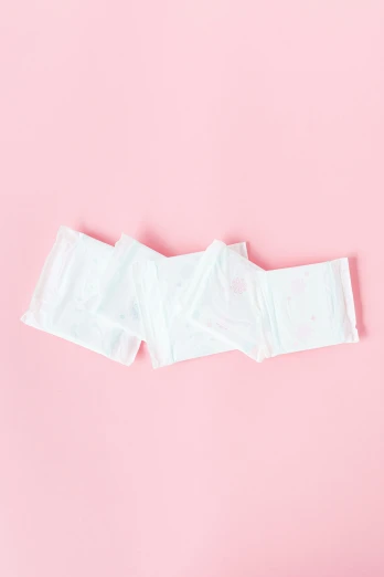a pair of underwear sitting on top of a pink surface, contracept, profile image, stacked image, folded