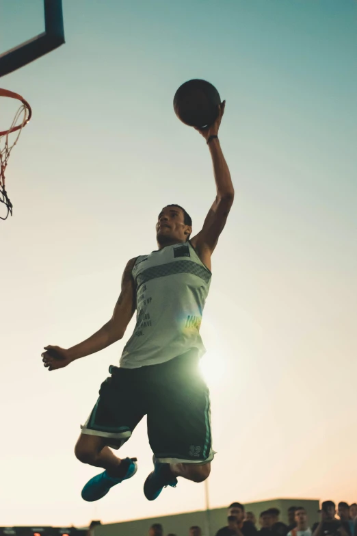 a man that is jumping in the air with a basketball, in the sun