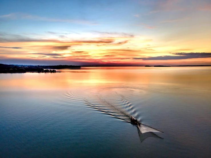 a person rowing a boat on a lake at sunset, by Jan Tengnagel, pexels contest winner, hurufiyya, twisted waterway, flying over the horizon, award winning color photo, wide high angle view