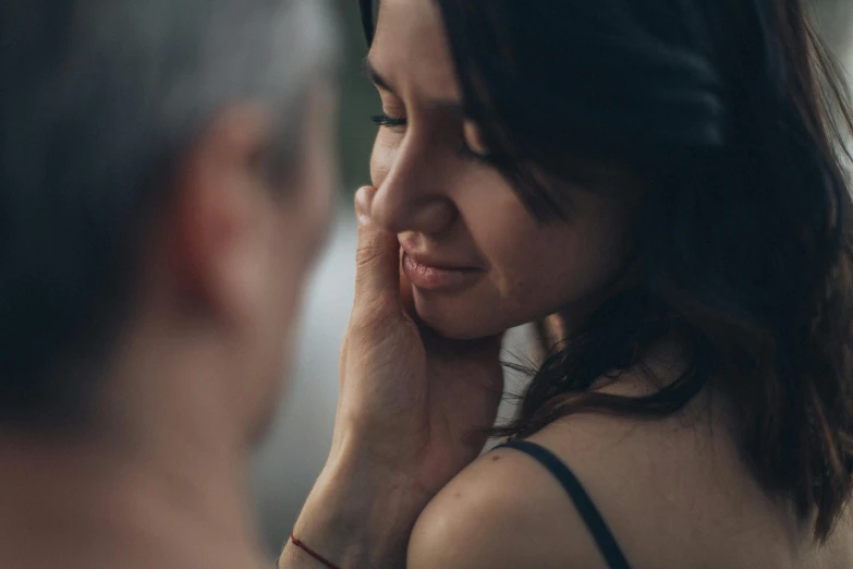 a close up of a person talking on a cell phone, intimate holding close, woman's face looking off camera, shy looking down, intimate lighting