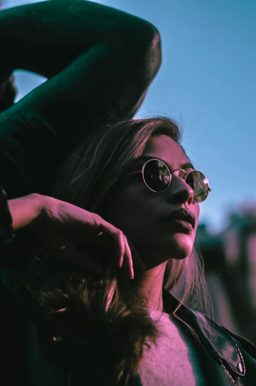 a woman wearing glasses and a leather jacket, a picture, inspired by Elsa Bleda, trending on pexels, aestheticism, summer evening, dark shades, low angle photograph, sunfaded