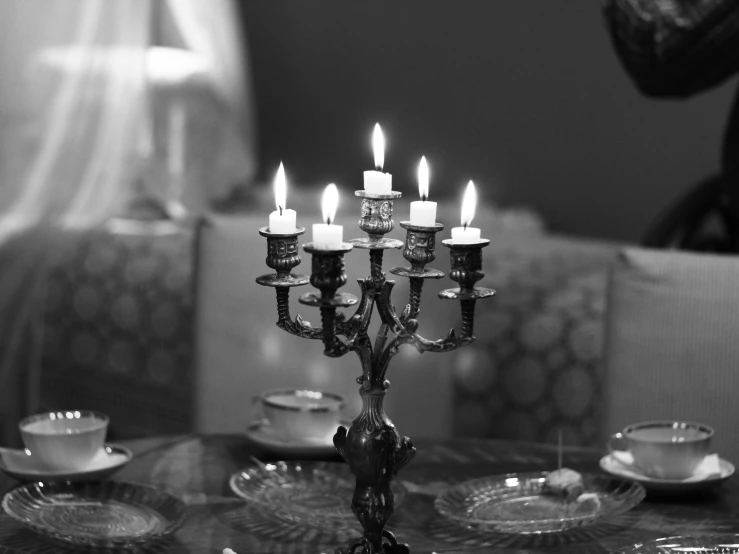 a group of candles sitting on top of a table, a black and white photo, by Caroline Mytinger, pixabay, baroque, dinner is served, morrocan lamp, nikolay kopeykin, dining room