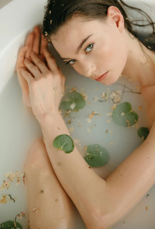 a beautiful young woman sitting in a bath tub, a photo, inspired by Elsa Bleda, trending on pexels, renaissance, made of leaves, flora-lush-crater, skin care, clover