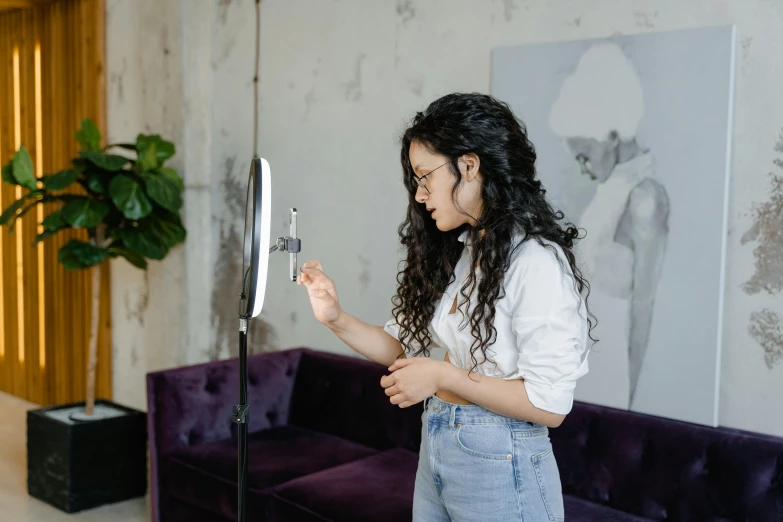 a woman standing in front of a fan in a living room, a polaroid photo, trending on pexels, putting makeup on, holding an activated lightsaber, professional profile picture, girl in studio