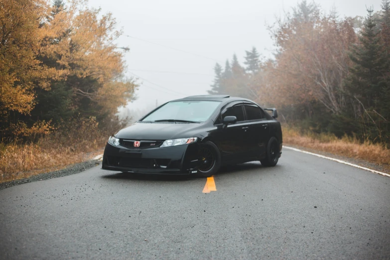 a black car parked on the side of a road, by Matt Cavotta, pexels contest winner, honda civic, fall season, avatar image, samurai vinyl wrap