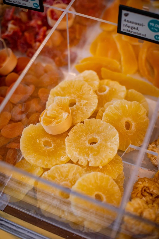 a display case filled with lots of different types of fruit, slices of orange, sunny amber morning light, sugar, upclose