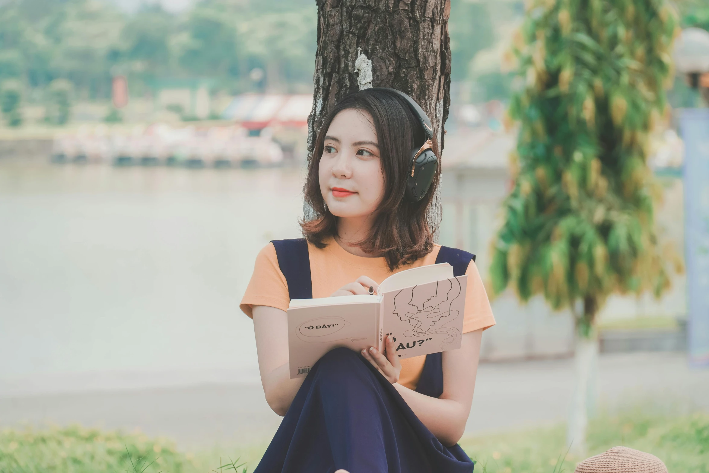 a woman sitting under a tree reading a book, pexels contest winner, realism, wearing modern headphone, avatar image, asian women, professional profile picture