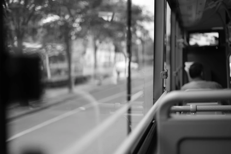 a black and white photo of people on a bus, a black and white photo, unsplash, realism, transparent glass, realistic », tilt shift glass background, tram