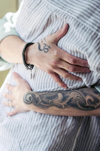 a woman that has a tattoo on her arm, symbolism, pregnant, swirly, holding each other hands, lgbtq
