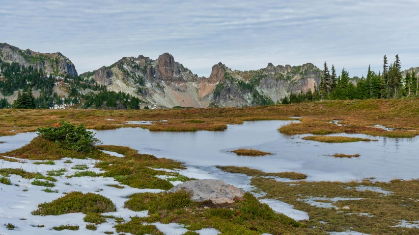 a body of water sitting on top of a snow covered field, by Jessie Algie, unsplash contest winner, alpine pond with water lilies, devils horns, pacific northwest coast, 2 0 2 2 photo