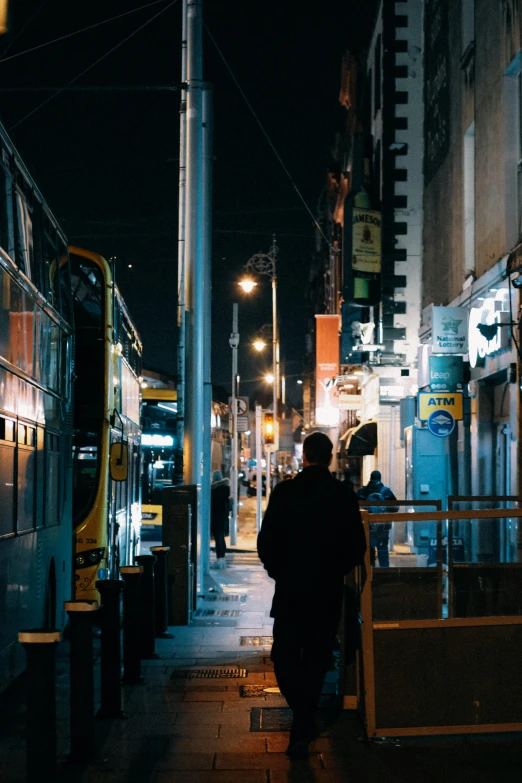 a person walking down a city street at night, by Niko Henrichon, trending on unsplash, deserted shinjuku junk town, street tram, back alley, a very sad man