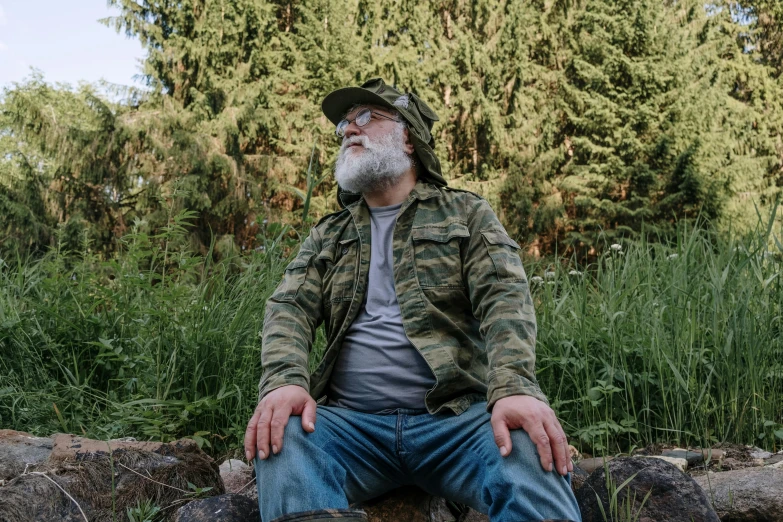 a man with a beard sitting on a rock, pexels, figuration libre, overalls and a white beard, wearing camo, avatar image, father figure image