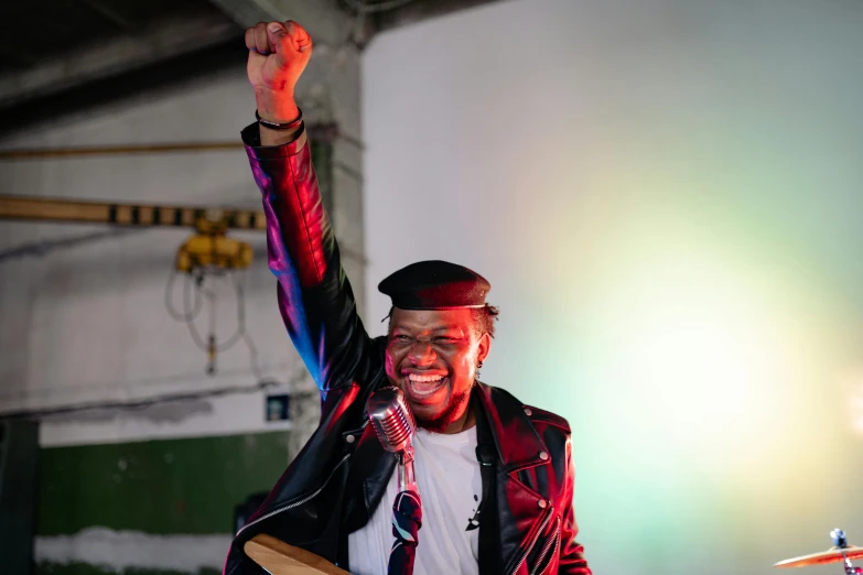 a man holding a baseball bat on top of a stage, an album cover, unsplash, happening, george clinton, pose(arms up + happy), soft light, portrait mode photo