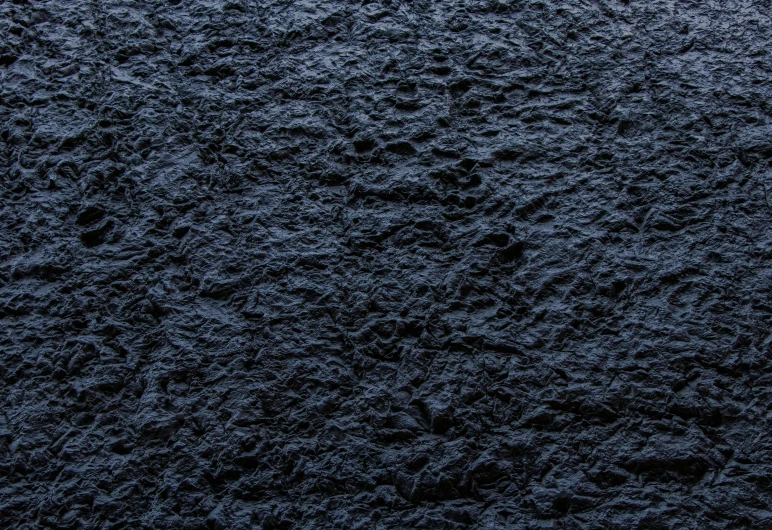 a close up of a black textured surface, inspired by Toss Woollaston, dark blue water, volumetric wool felting, lacquered, dim lit