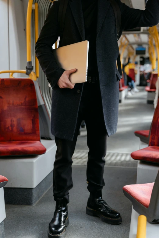 a man standing on a train holding a folder, happening, man steal computers, australian, functional and elegant look, trending photo