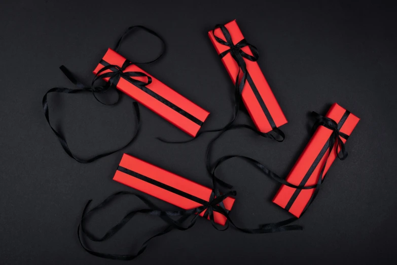 a group of red dynamites on a black background, by Emma Andijewska, pexels contest winner, birthday wrapped presents, silk belt, packaging, ninja scrolls