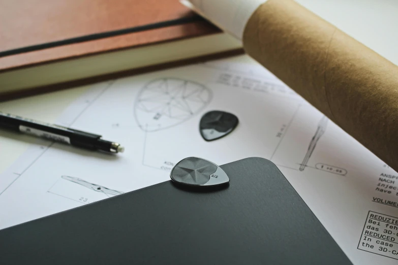 a laptop computer sitting on top of a table, a detailed drawing, inspired by Zaha Hadid, unsplash, academic art, sharp metal crest, matte black paper, clipboard, small manufacture