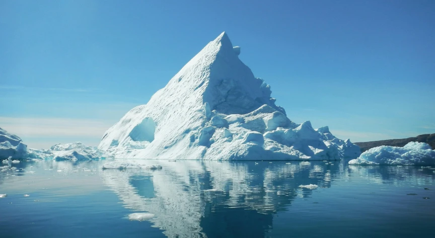 a large iceberg in the middle of a body of water, pexels contest winner, clear blue skies, raymarching, nordic, cone shaped