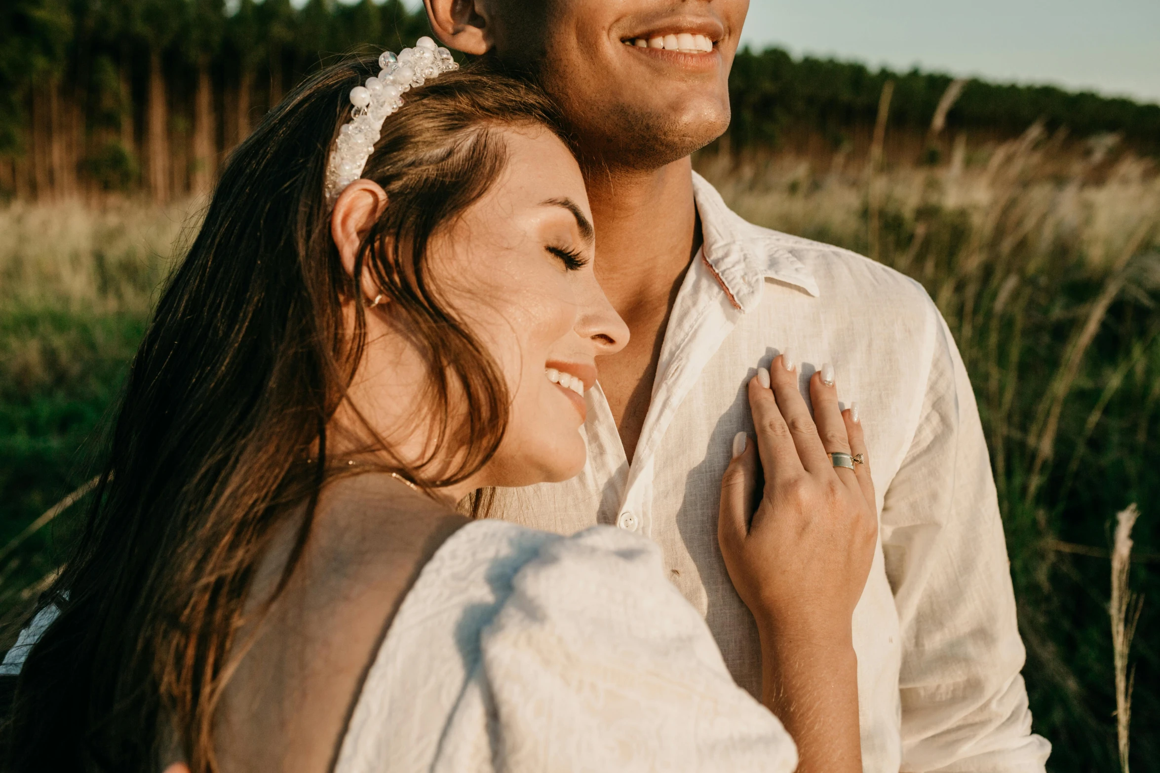 a man standing next to a woman in a field, trending on pexels, hair jewellery, detailed smile, wearing white clothes, couple on bed