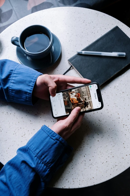 a person sitting at a table with a cell phone, a picture, trending on unsplash, happening, style steve mccurry, behance lemanoosh, high resolution product photo, shot on iphone 1 3 pro