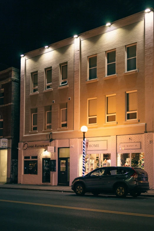 a car parked in front of a building at night, renaissance, storefronts, small town, profile image, downtown