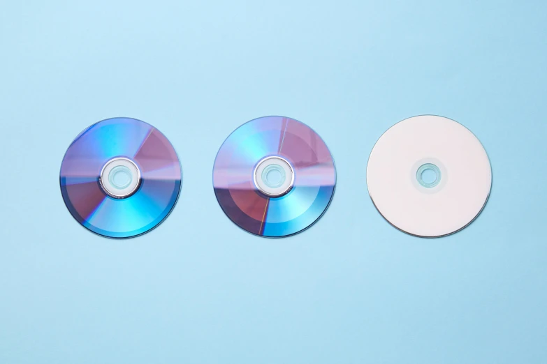 two cds sitting next to each other on a blue surface, by Julia Pishtar, unsplash, computer art, dvd, threes, three colors, rinko kawauchi