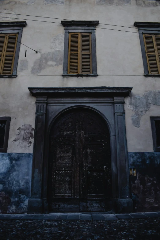 a tall building with a clock on top of it, an album cover, inspired by Eliseu Visconti, pexels contest winner, renaissance, doorway, faded chipped paint, naples, black house