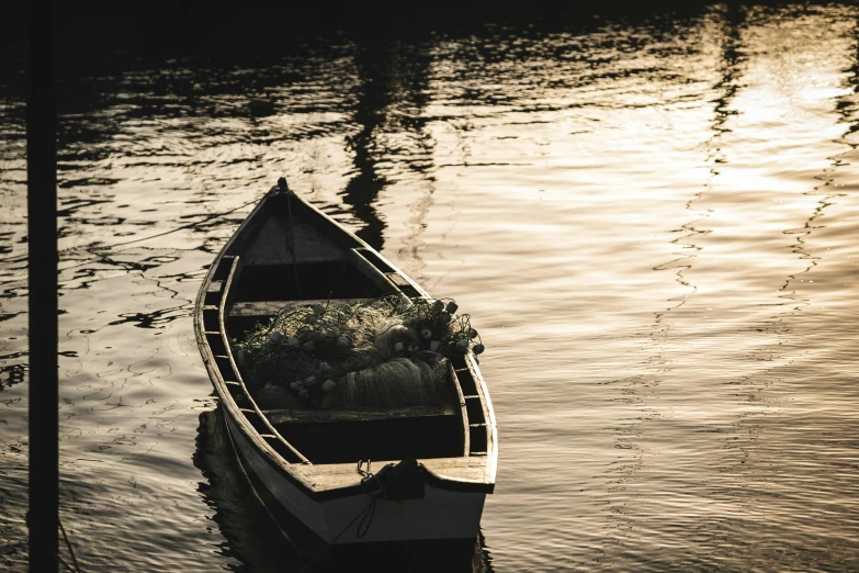 a boat sitting on top of a body of water, by Elsa Bleda, pexels contest winner, australian tonalism, golden sunlight, a wooden, dark and white, simple composition
