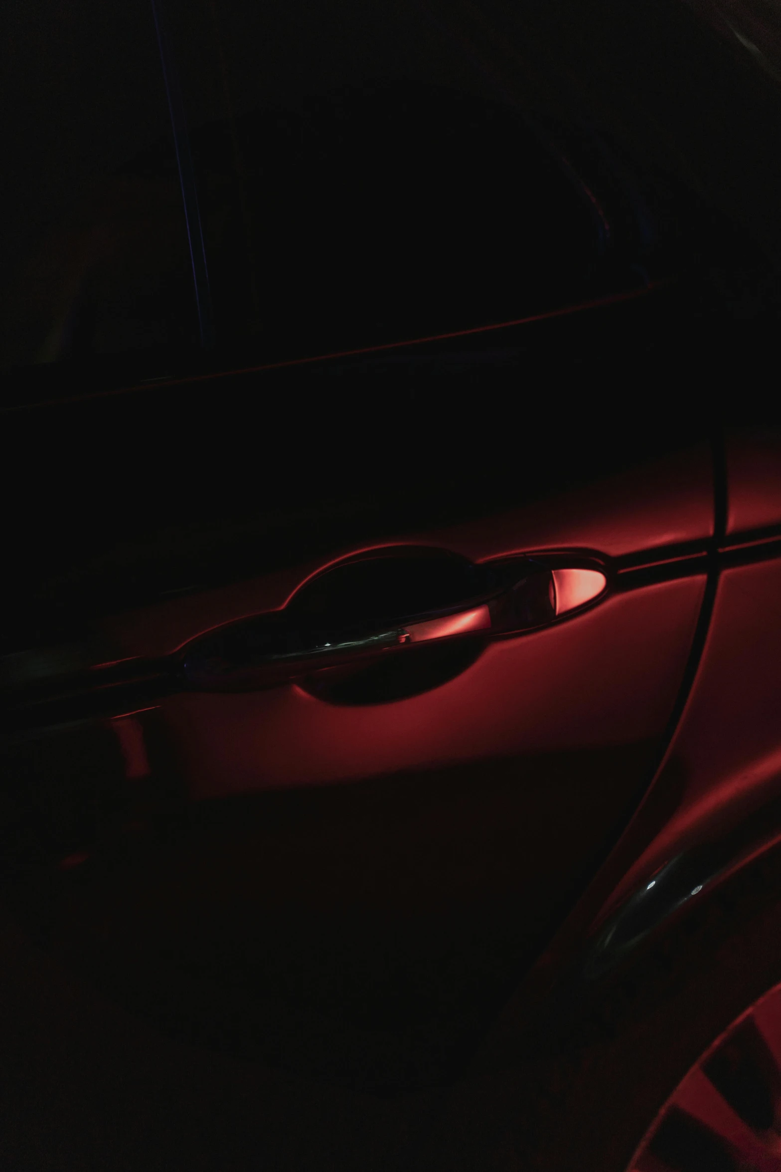 a close up of a car in the dark, an album cover, inspired by Elsa Bleda, chrome red, high body detail, red on black, medium-shot