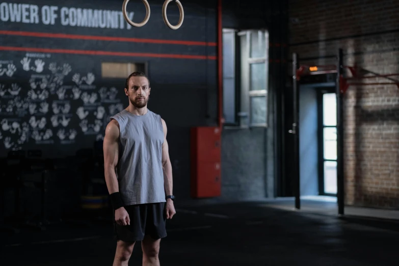 a man standing in the middle of a crossfit gym, a portrait, hurufiyya, portrait image